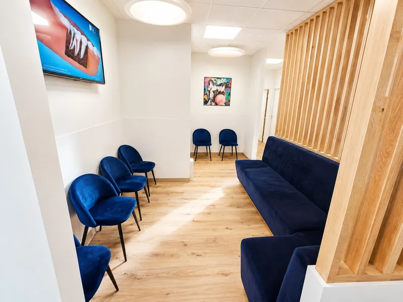 La salle d'attente, ses chaises et sa banquette en velours bleu marine